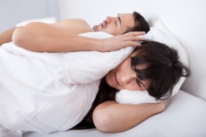 Snoring man, woman with pillow.